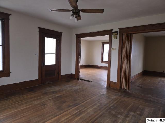 unfurnished room with ceiling fan and dark hardwood / wood-style flooring