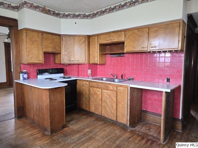 kitchen with sink, backsplash, dark hardwood / wood-style floors, white electric stove, and kitchen peninsula