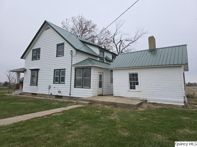 rear view of property with a patio and a yard