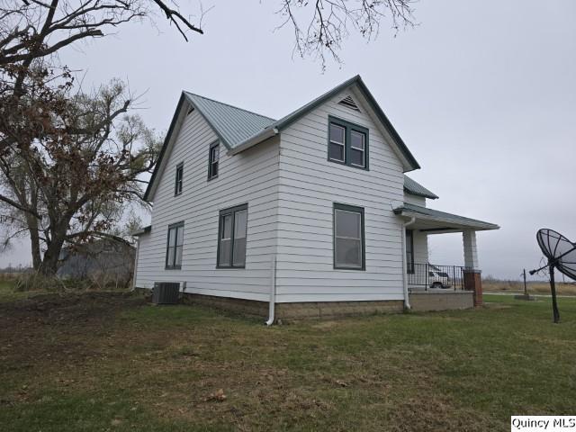 view of side of home featuring a lawn and central air condition unit