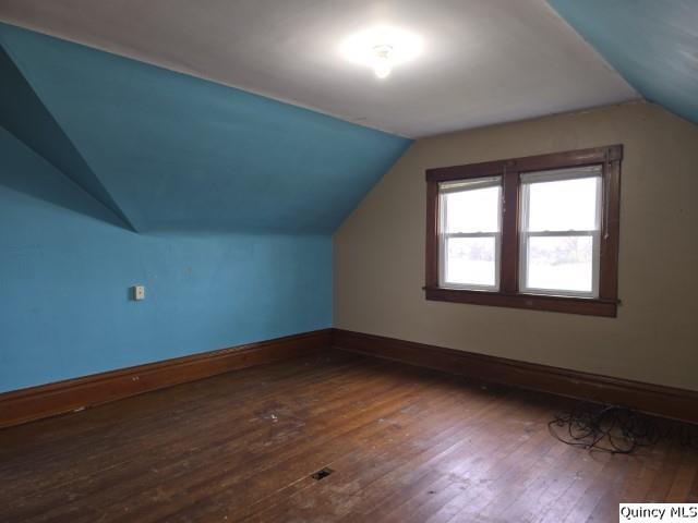 bonus room with dark hardwood / wood-style floors and vaulted ceiling