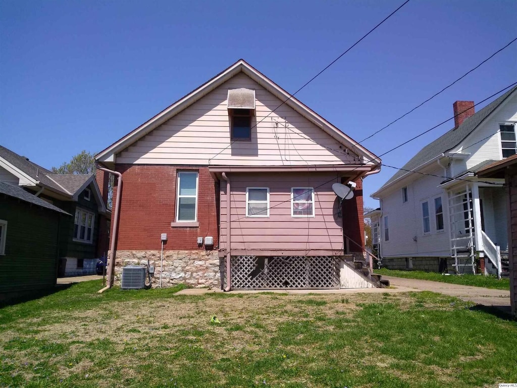 2050 Broadway St, Quincy, IL 62301 - back of house with central AC unit and a lawn