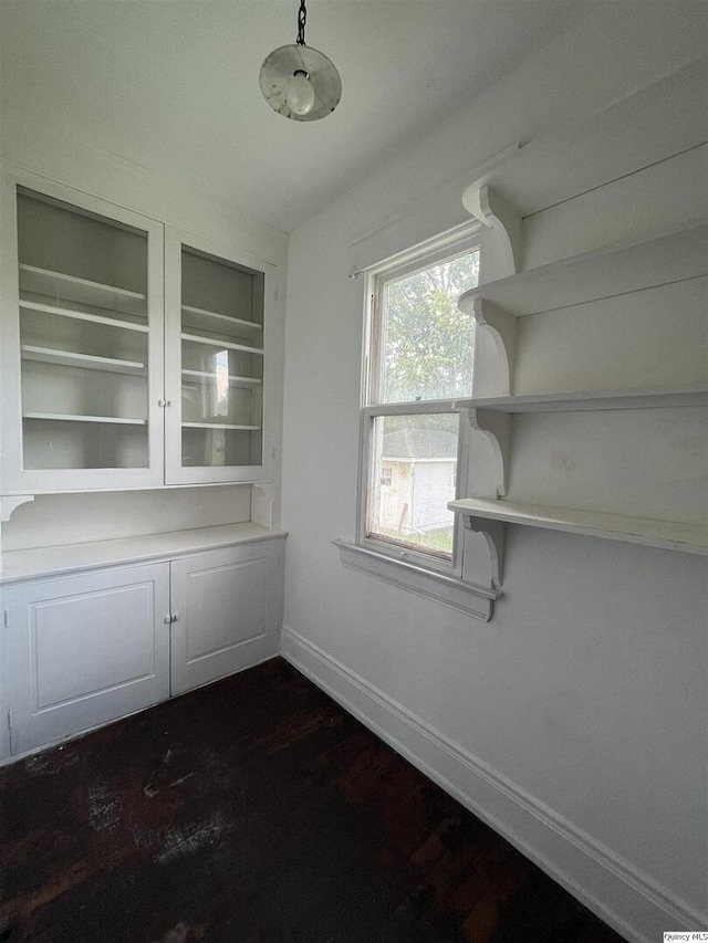 unfurnished dining area with dark wood-type flooring