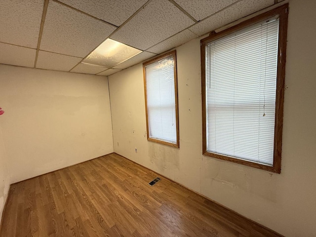 spare room with hardwood / wood-style floors and a paneled ceiling