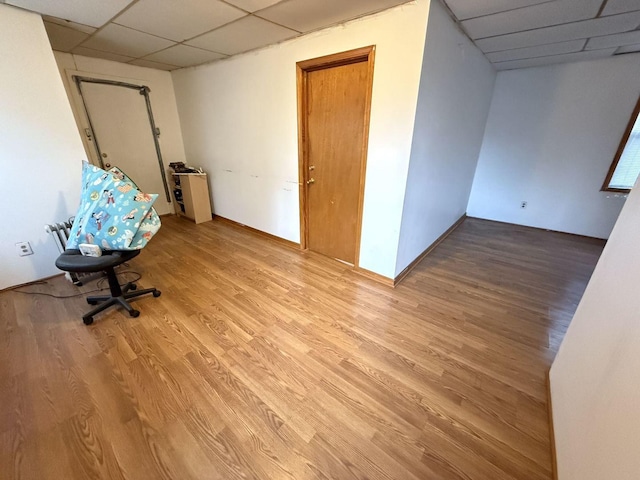 unfurnished office featuring hardwood / wood-style floors and a paneled ceiling