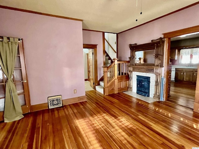 unfurnished living room with hardwood / wood-style floors and ornamental molding