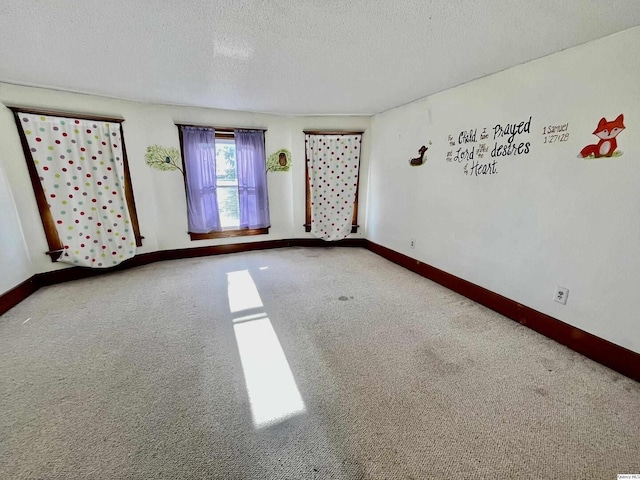 carpeted spare room with a textured ceiling