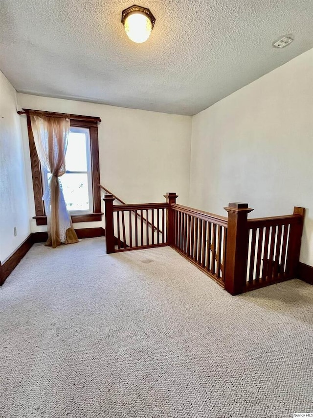 interior space featuring carpet floors and a textured ceiling