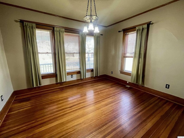 spare room featuring hardwood / wood-style flooring and ornamental molding