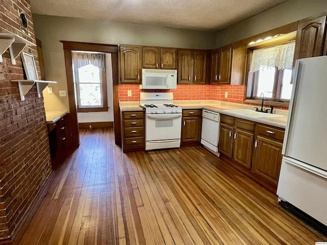 kitchen featuring white appliances, dark hardwood / wood-style flooring, sink, and a textured ceiling