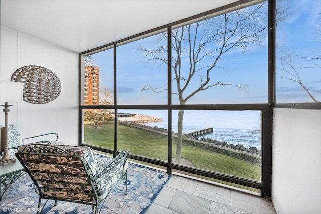 sunroom / solarium featuring a water view