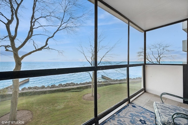 sunroom featuring a wealth of natural light and a water view