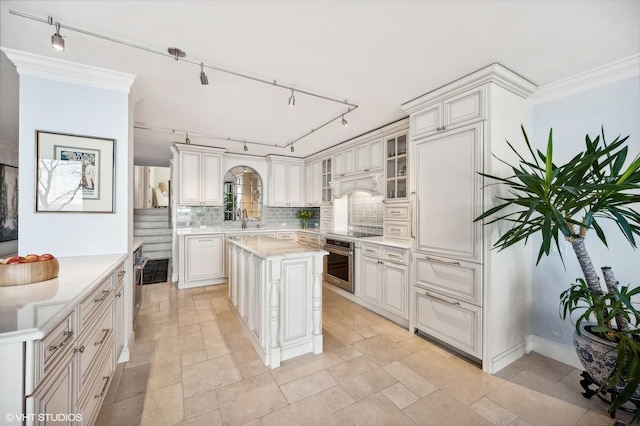 kitchen featuring white cabinetry, a kitchen island, sink, and stainless steel oven