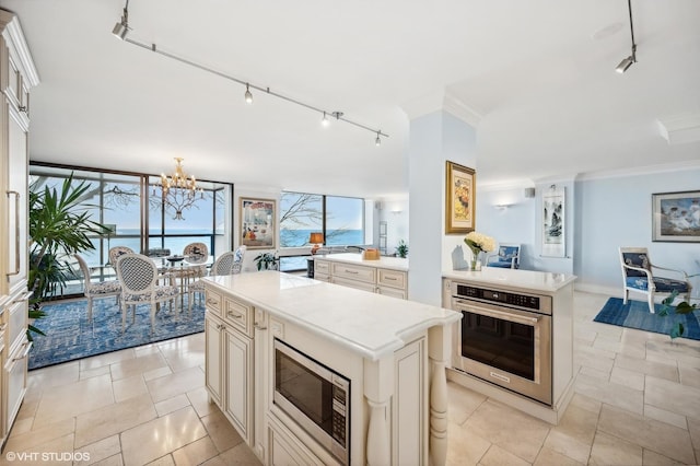 kitchen featuring a water view, appliances with stainless steel finishes, a center island, and a wall of windows