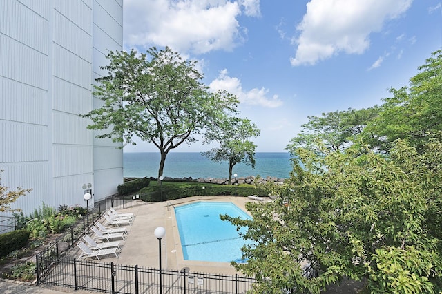 view of swimming pool featuring a patio and a water view