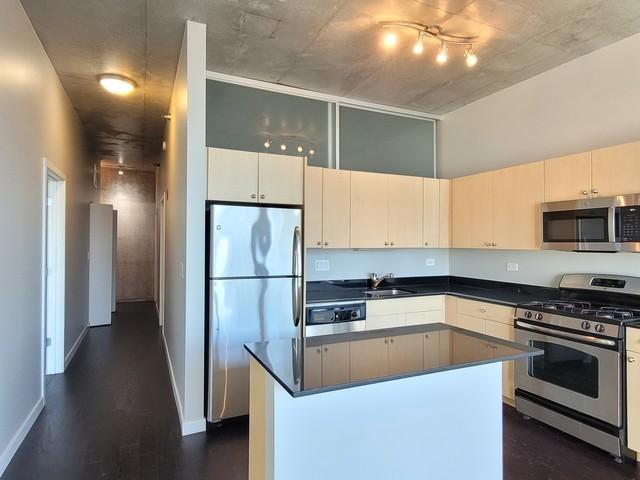 kitchen with a center island, sink, appliances with stainless steel finishes, and dark wood-type flooring