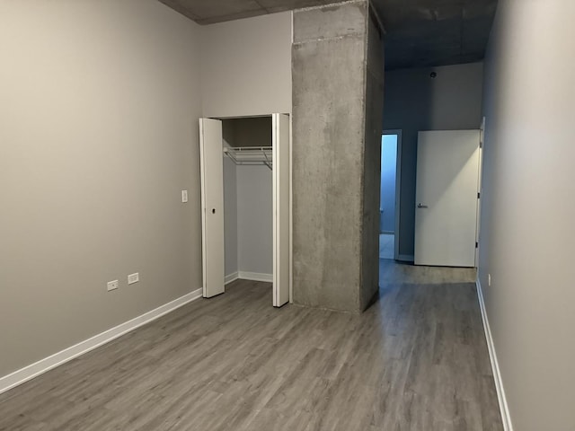 unfurnished bedroom featuring wood-type flooring and a closet