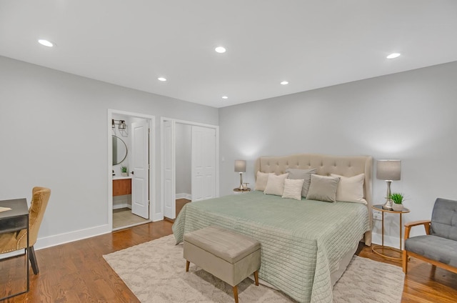 bedroom featuring hardwood / wood-style flooring and connected bathroom