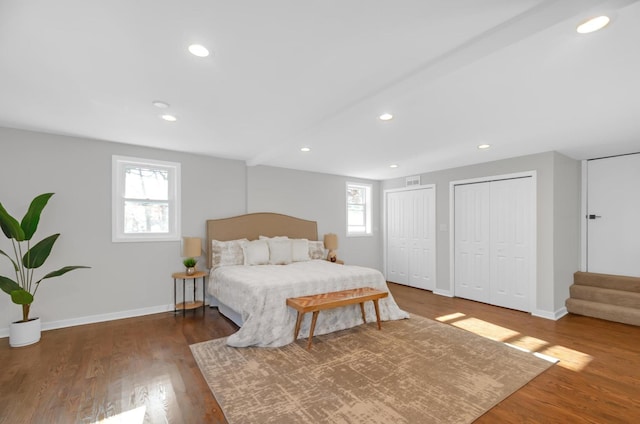 bedroom featuring dark hardwood / wood-style flooring and two closets