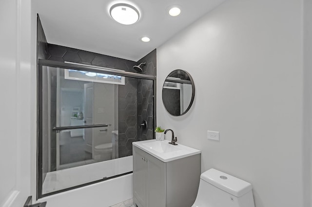 full bathroom featuring vanity, toilet, and bath / shower combo with glass door