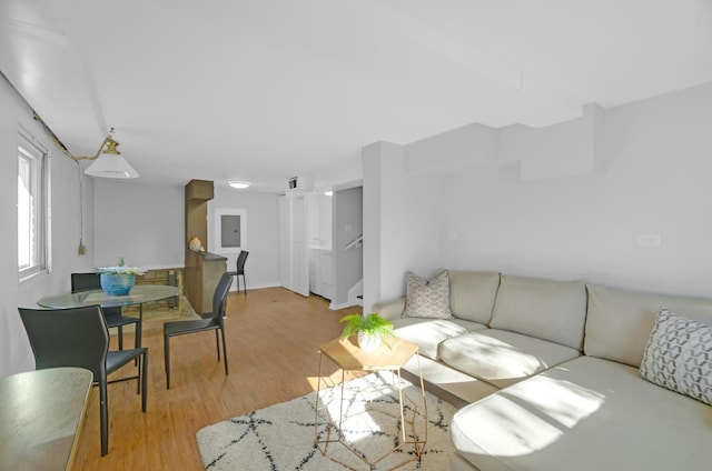 living room featuring electric panel and light hardwood / wood-style flooring