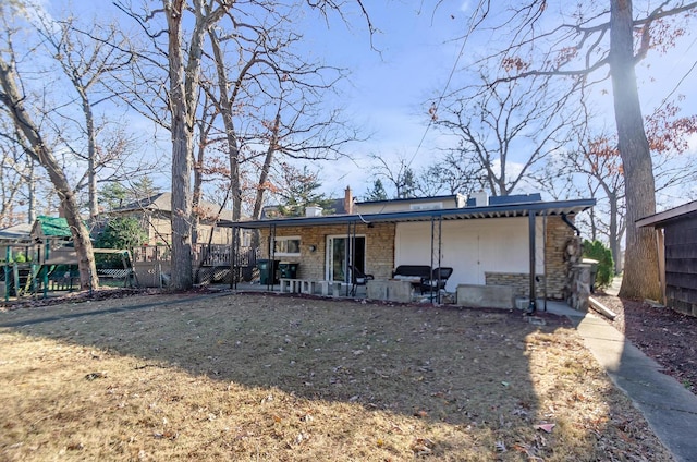 rear view of property featuring a yard and a patio area