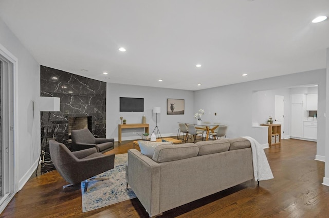 living room with a high end fireplace and hardwood / wood-style flooring