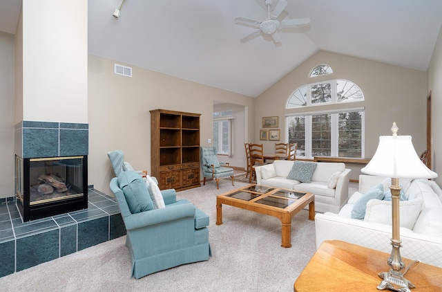 living room featuring ceiling fan, carpet, high vaulted ceiling, and a fireplace