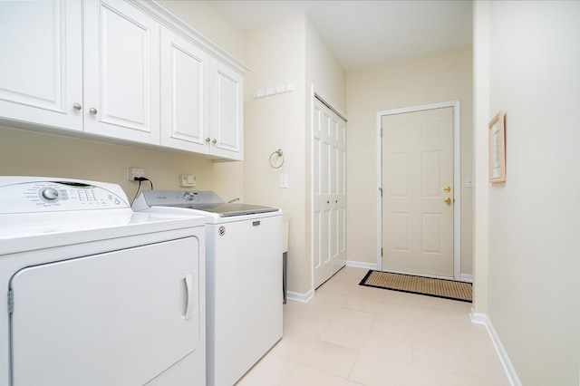 laundry area featuring washer and clothes dryer and cabinets