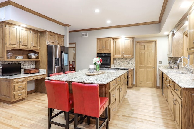 kitchen featuring visible vents, open shelves, a sink, stainless steel fridge with ice dispenser, and light wood finished floors