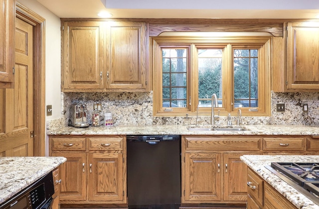 kitchen with light stone countertops, a sink, decorative backsplash, stainless steel gas stovetop, and black dishwasher