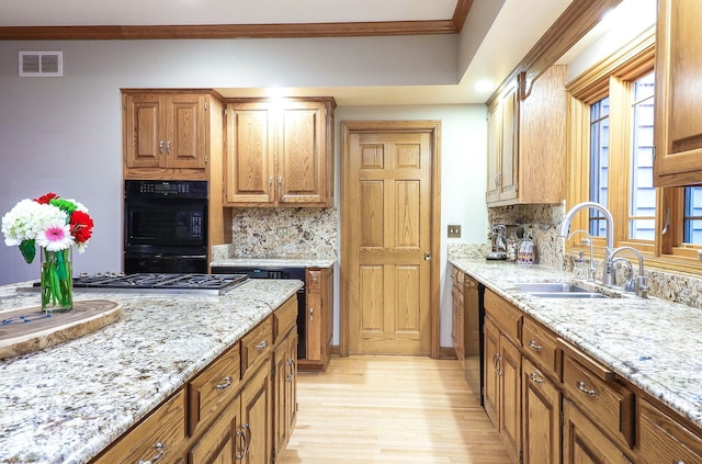 kitchen with visible vents, ornamental molding, a sink, light stone counters, and dishwasher