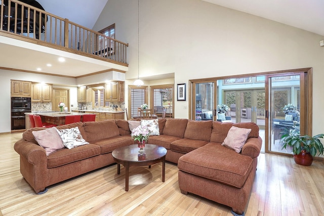living room featuring high vaulted ceiling and light wood-style flooring