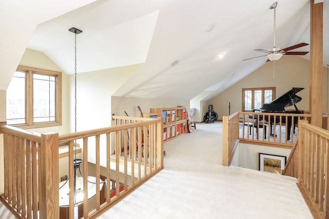 corridor with an upstairs landing, carpet, and vaulted ceiling