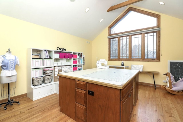 kitchen with baseboards, lofted ceiling, light wood-style floors, and brown cabinetry