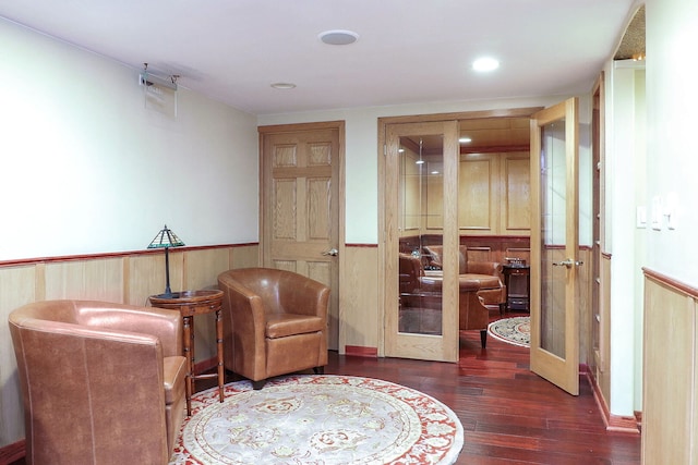 living area with wood-type flooring and wainscoting