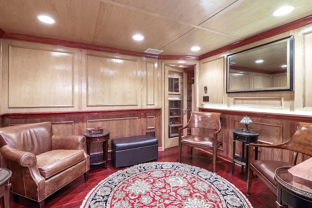 living area featuring dark wood finished floors, visible vents, recessed lighting, and wooden walls