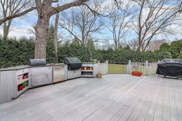 wooden terrace featuring exterior kitchen and grilling area