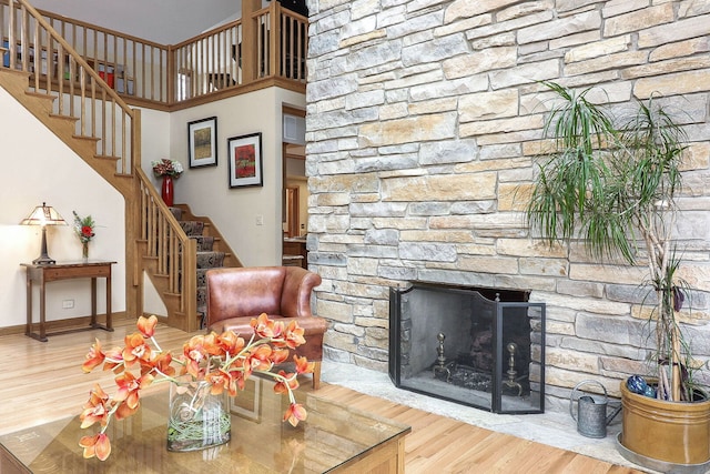 living area with stairs, wood finished floors, baseboards, and a fireplace
