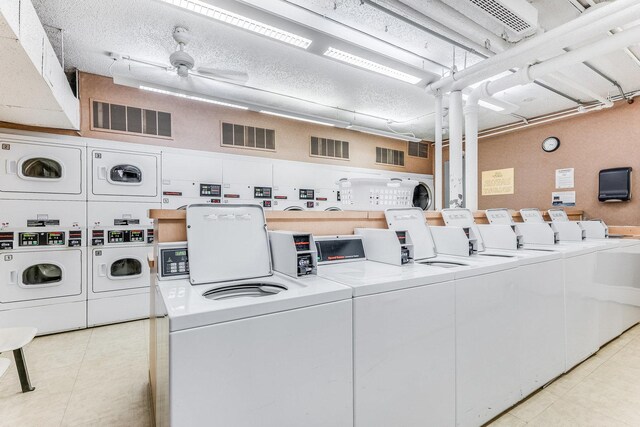 clothes washing area with washer and dryer, a textured ceiling, stacked washing maching and dryer, and ceiling fan