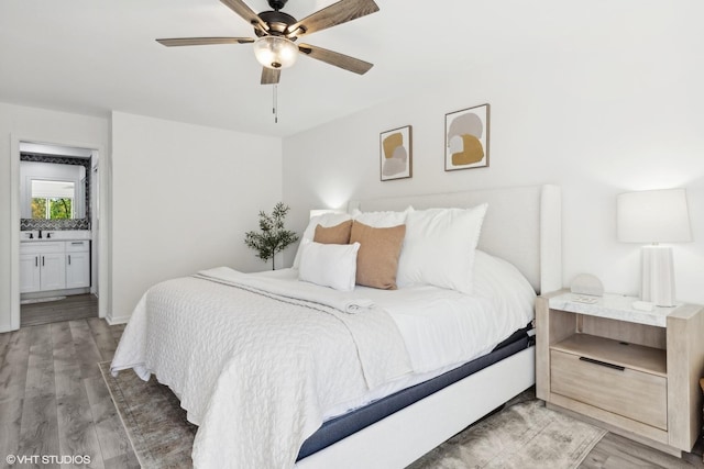 bedroom featuring ensuite bath, ceiling fan, hardwood / wood-style floors, and sink