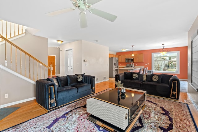 living room featuring ceiling fan and light hardwood / wood-style flooring