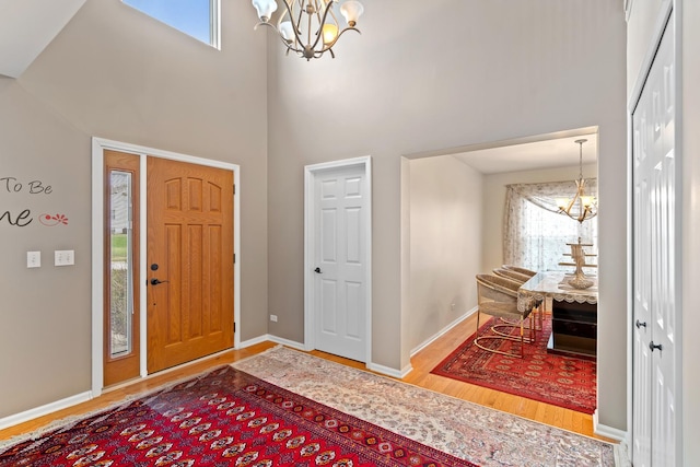 foyer entrance with hardwood / wood-style flooring, a high ceiling, and a chandelier