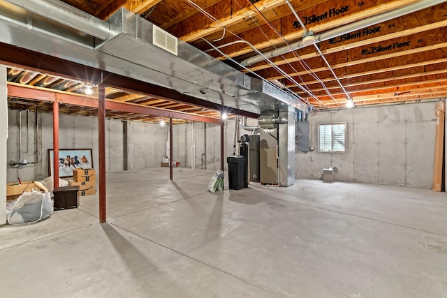 basement with heating unit, water heater, and electric panel