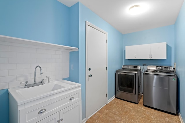 laundry area featuring cabinets, sink, and washing machine and dryer