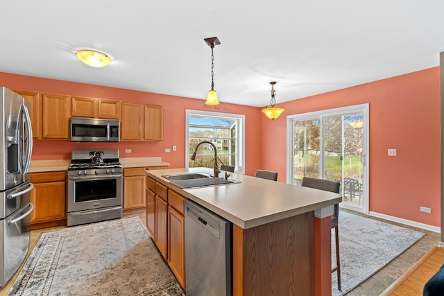 kitchen with a kitchen island with sink, sink, plenty of natural light, and appliances with stainless steel finishes