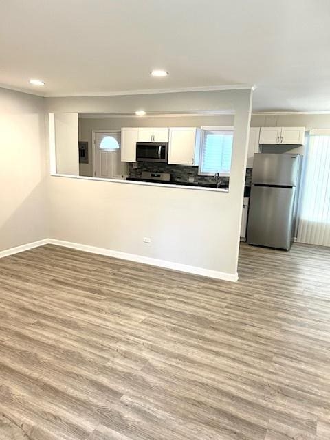 kitchen with white cabinets, light wood-type flooring, and appliances with stainless steel finishes