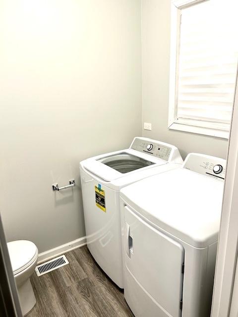 laundry room with washing machine and dryer and dark wood-type flooring