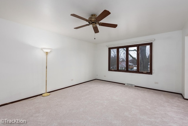 spare room with ceiling fan and carpet