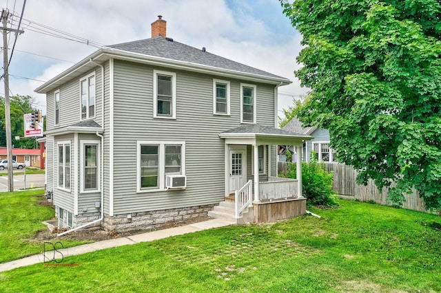 rear view of property featuring cooling unit and a yard